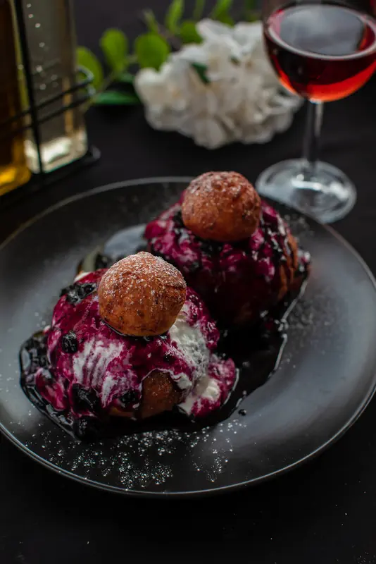 Desert tradițional cu găluște și sos de vișine, servit cu un pahar de vin