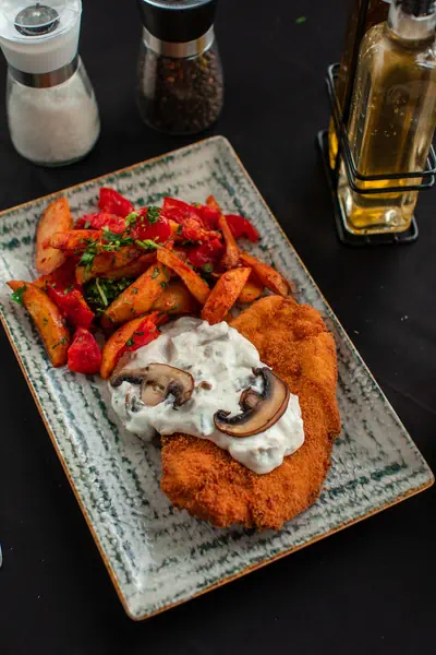 Șnițel crocant cu sos de ciuperci și cartofi copți, servit la La Mami Acasă