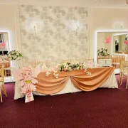 Decorated head table with floral arrangements in La Mami Acasa event hall